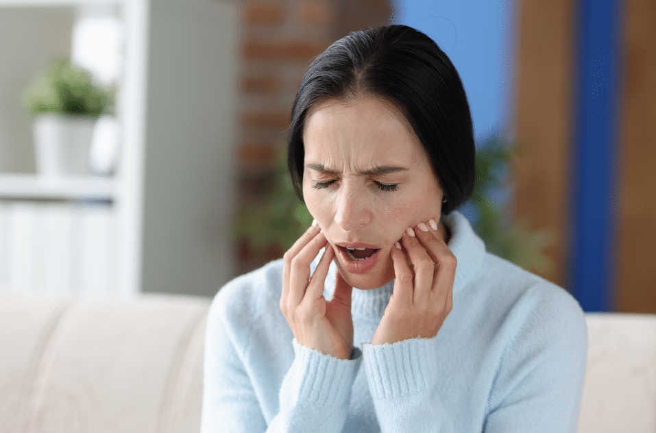 Woman holding her jaw suffering from TMJ