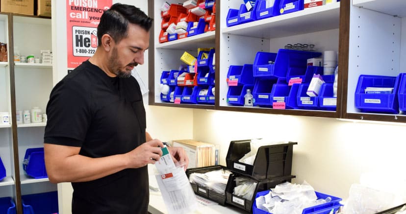 Male Employee Filling a Take-Home Medpack with A Supply of Prescribed Medications