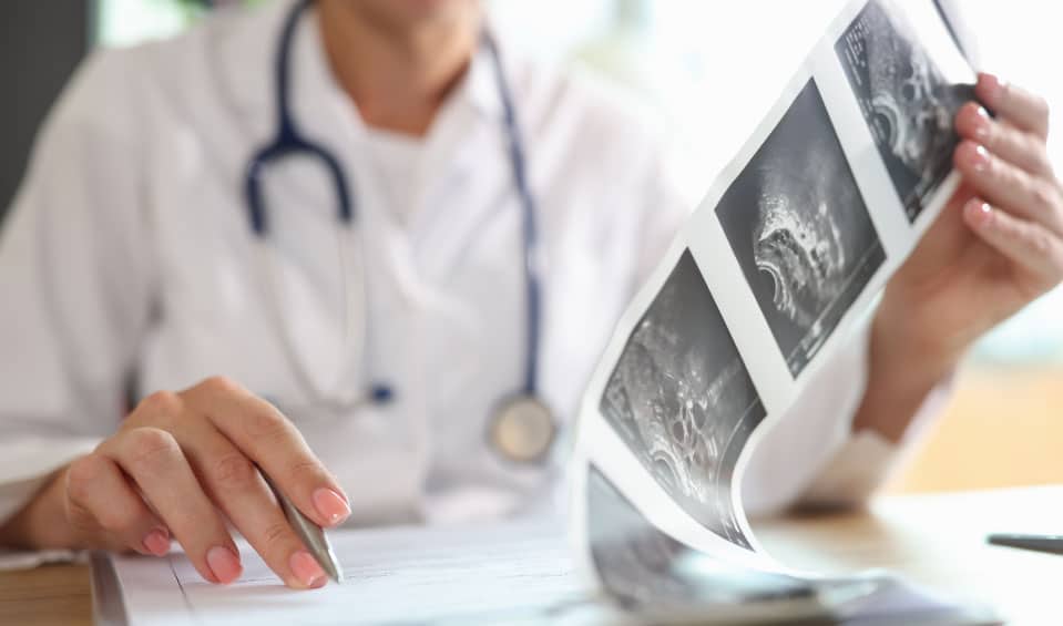 Board-certified obstetrician reviewing patient's ultrasound